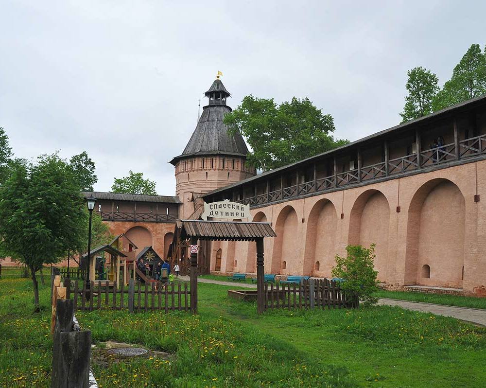 Детинец (детская площадка) на фоне крепостной стены.